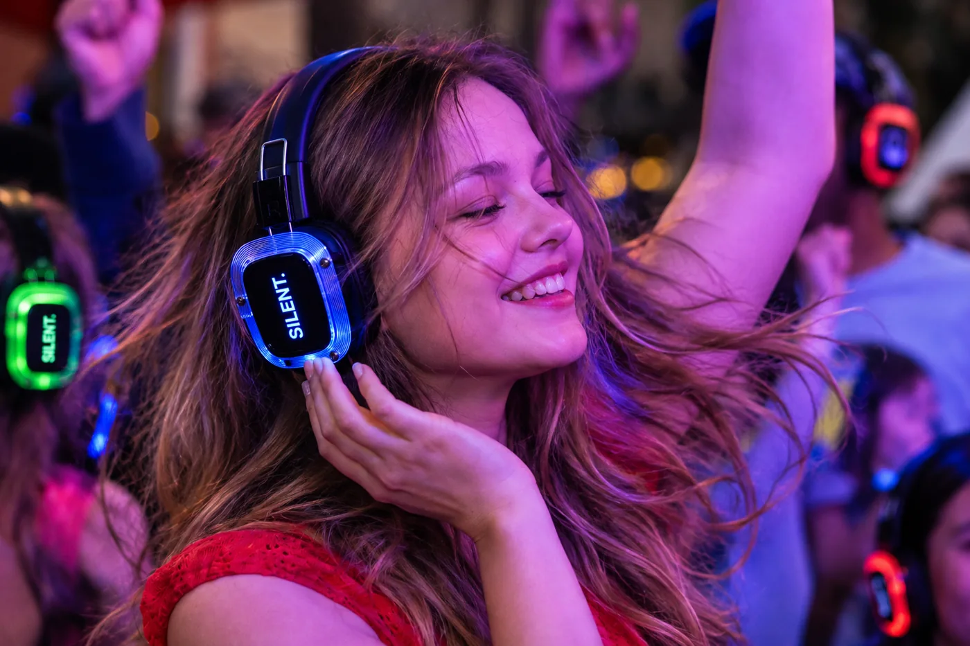 Усміхнена дівчина крупним планом слухає музику в навушниках Silent Disco