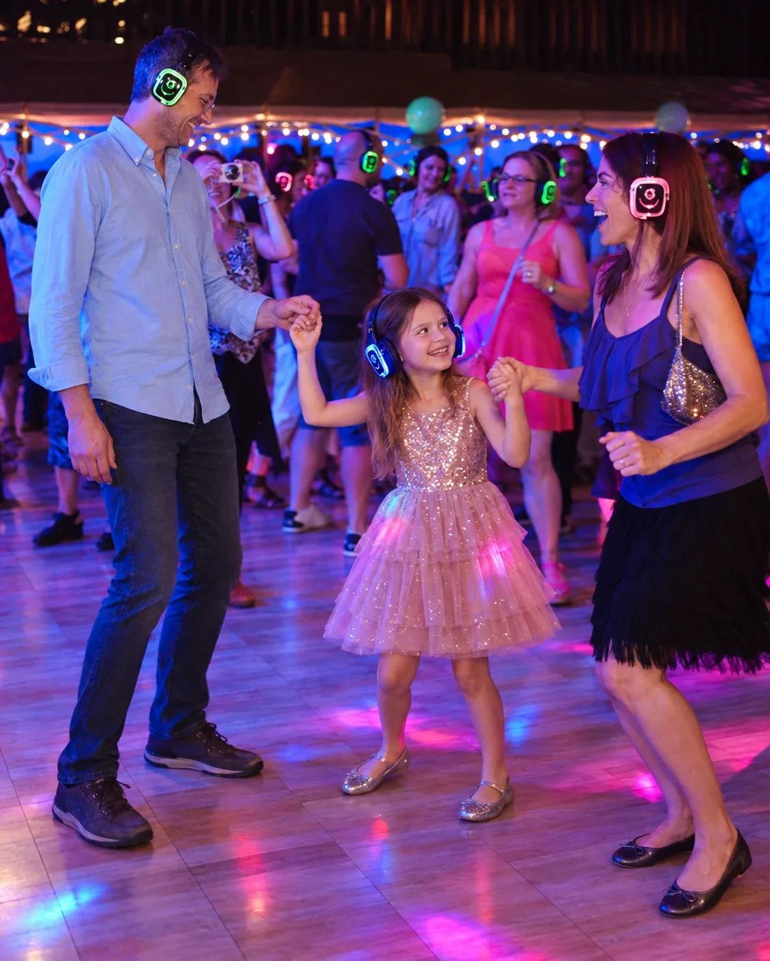 Родина з донькою танцює в навушниках Silent Disco на святковому майданчику